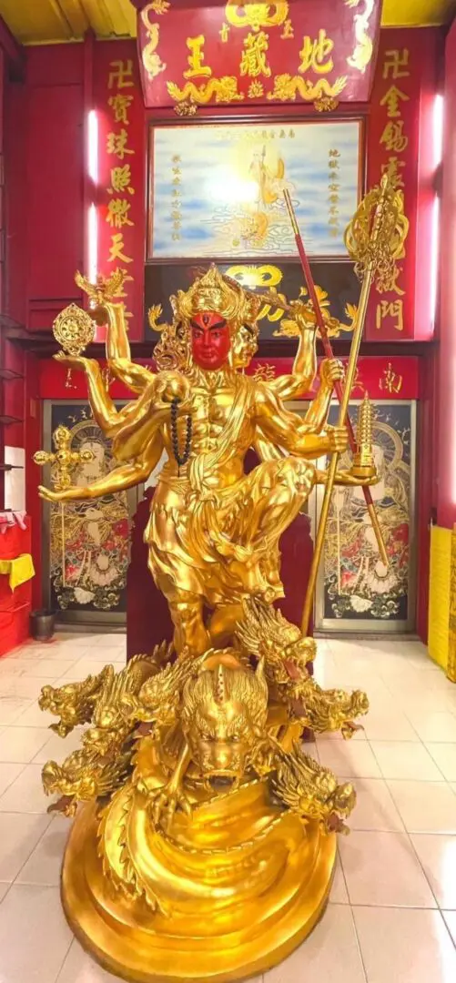 A statue of an asian deity in gold.